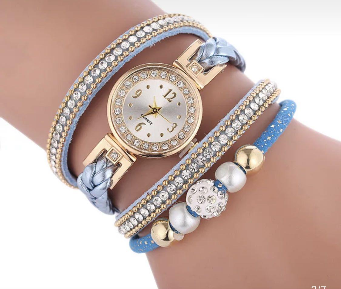 Gold watch with a blue bracelet, strap wrapped