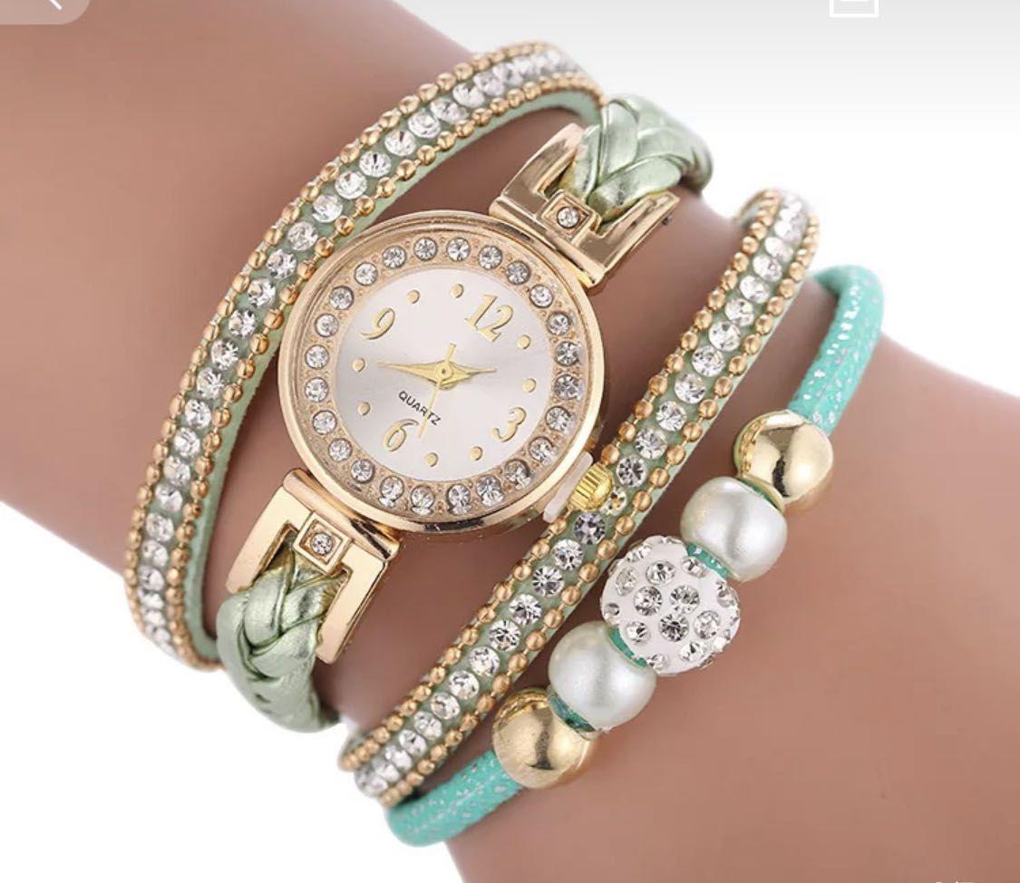 Gold watch with a green bracelet, strap wrapped