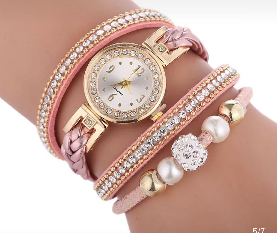Gold watch with a pink bracelet, strap wrapped
